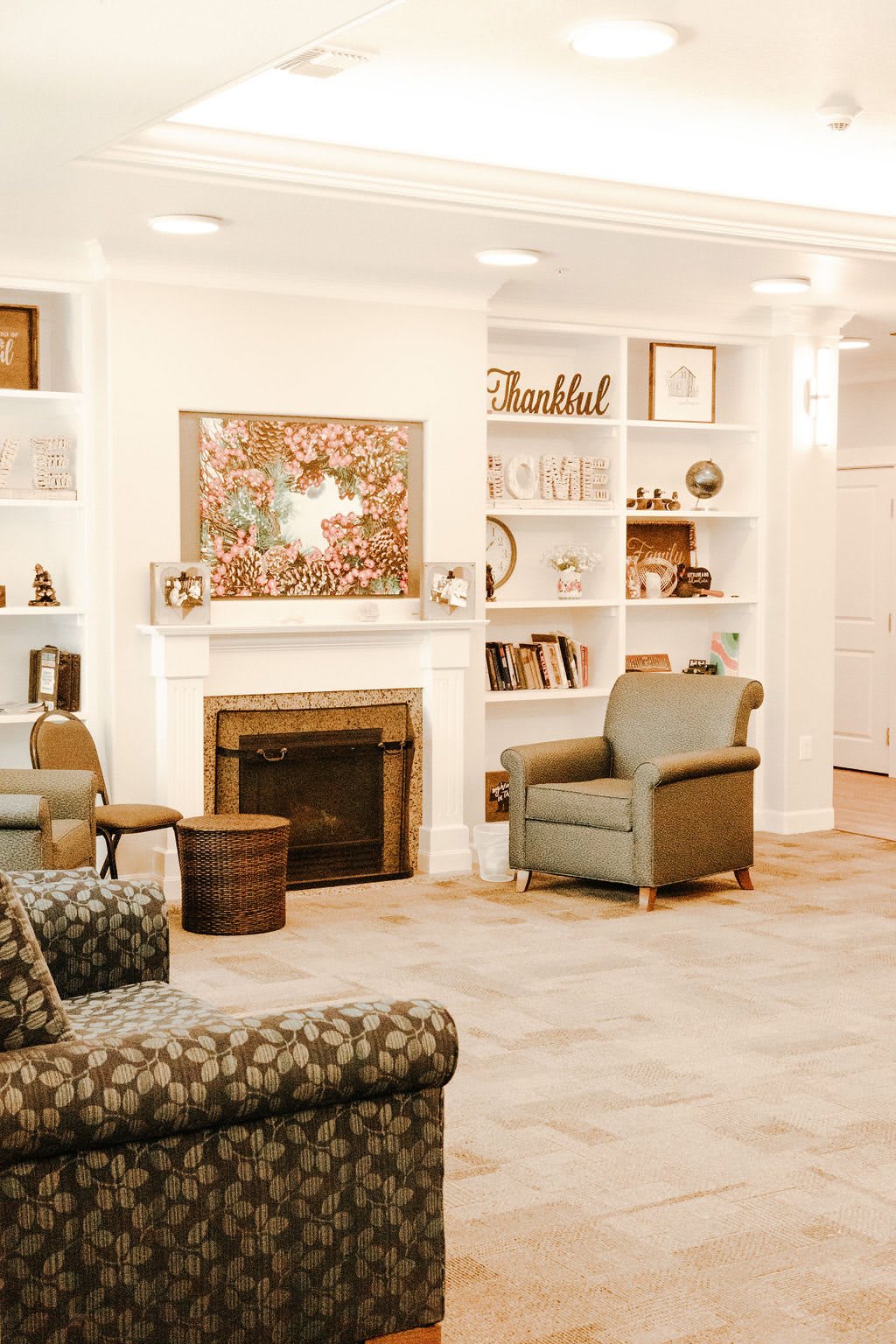 A cozy living room featuring a fireplace surrounded by built-in shelves and comfortable armchairs.