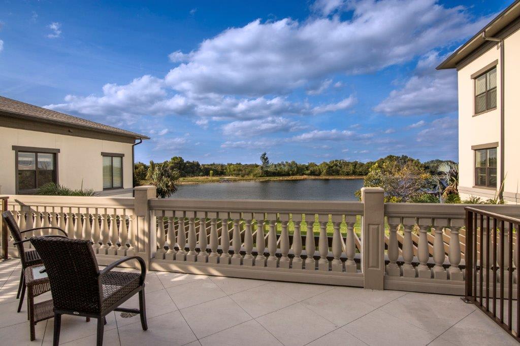 A scenic view from a balcony overlooking a tranquil lake on a sunny day.