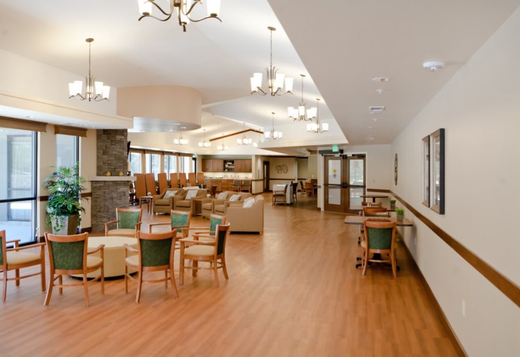 A spacious and well-lit lounge area with comfortable seating and tables.