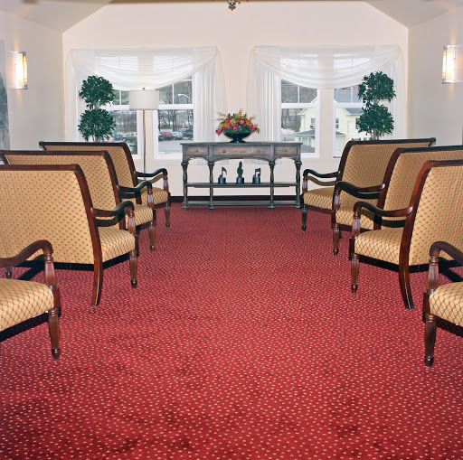 A well-lit waiting area featuring elegant chairs and decorative plants.