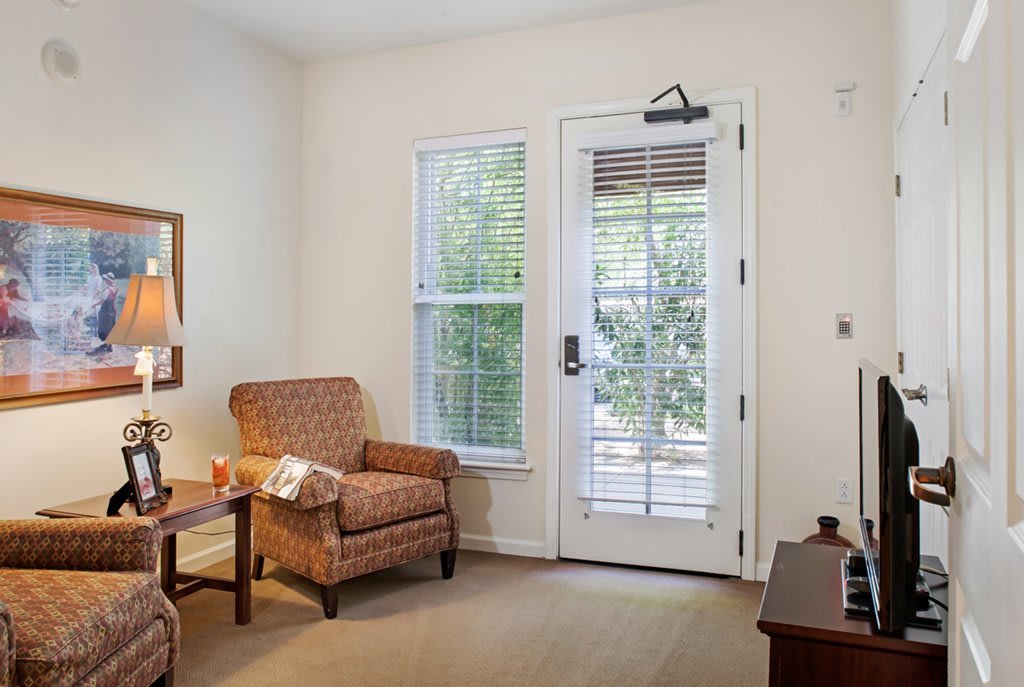 A cozy living room with an armchair and natural light coming through the windows.