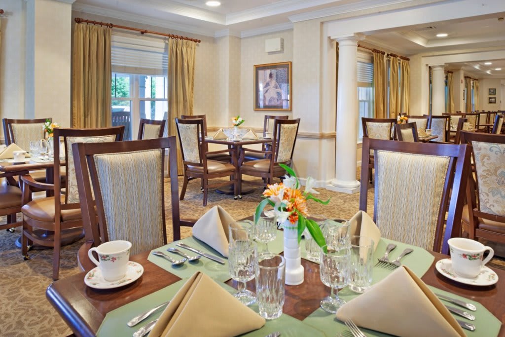 An elegant dining room with a formal table setting, featuring neatly arranged napkins and glassware.