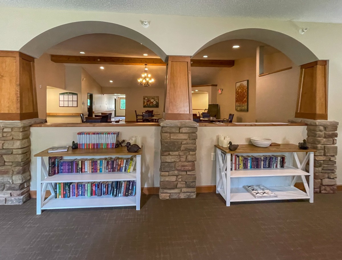A cozy interior with bookshelves and archways, creating a welcoming home library atmosphere.
