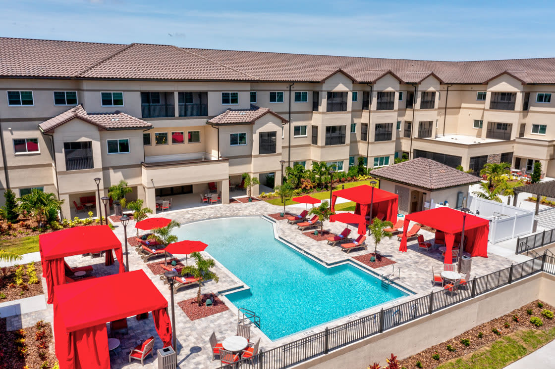 Luxury apartment complex with a swimming pool and red cabanas.