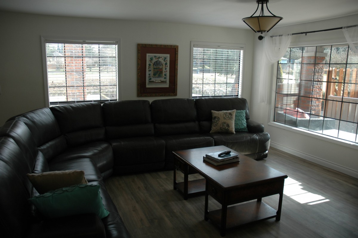 A cozy living room with a large sectional sofa, coffee table, and plenty of natural light.