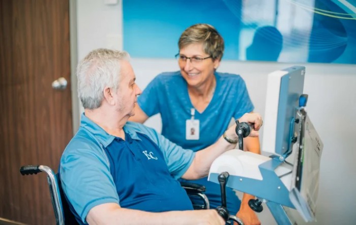 A healthcare professional assists a patient during a therapy session.