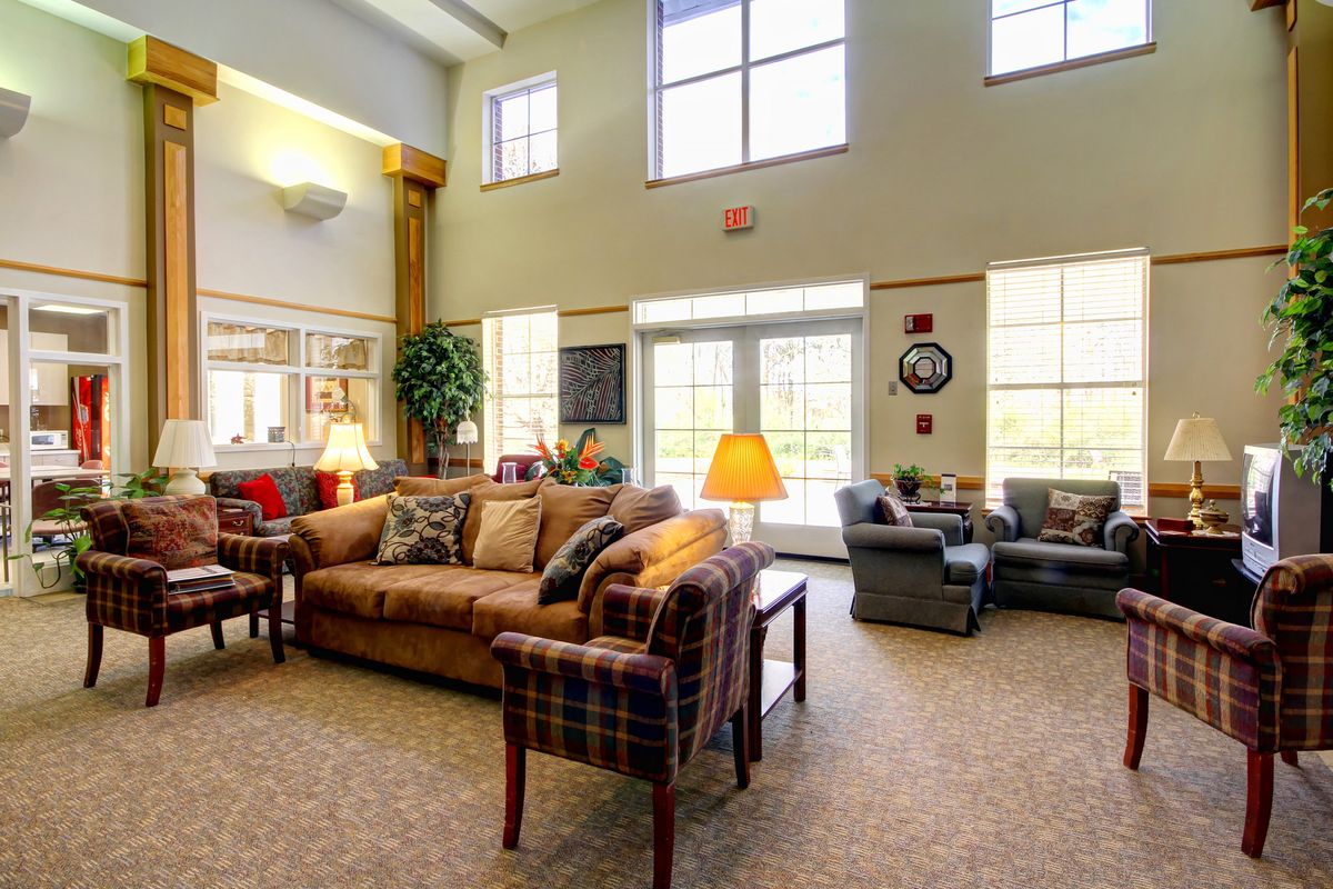 A spacious and well-lit living room with comfortable sofas and large windows.