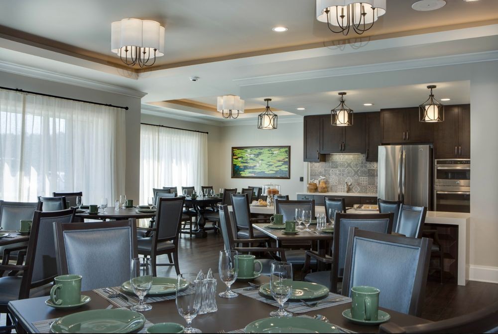 A modern dining room with elegant decor, featuring neatly set tables and stylish chandeliers.