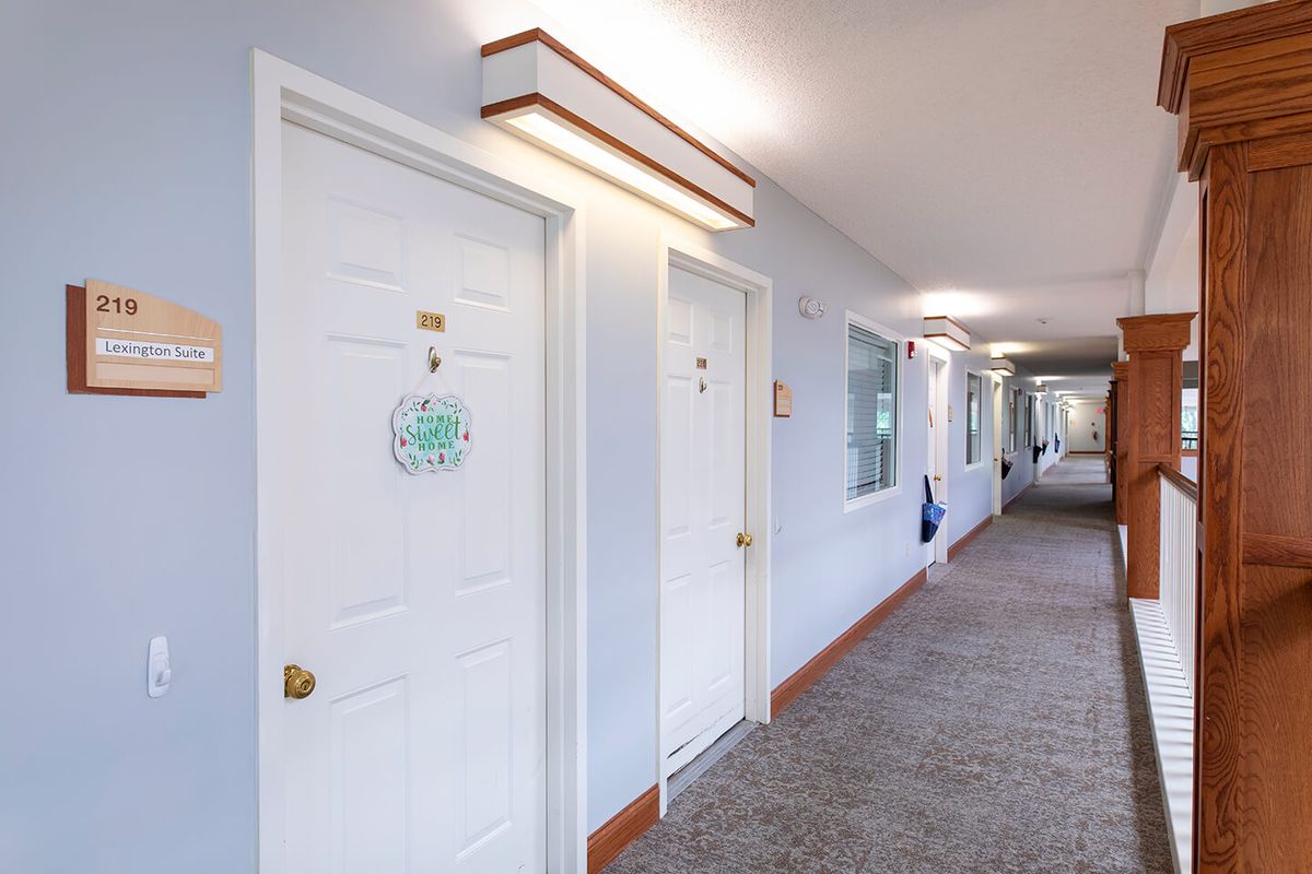 A well-lit hallway with several doors and light fixtures.
