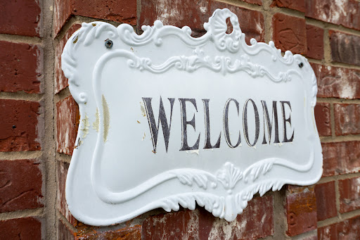 A charming white welcome sign with an ornate design, inviting guests into the home.