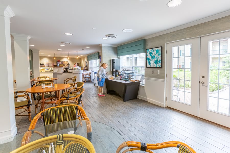 A cozy cafe interior with tables, chairs, and a service counter.