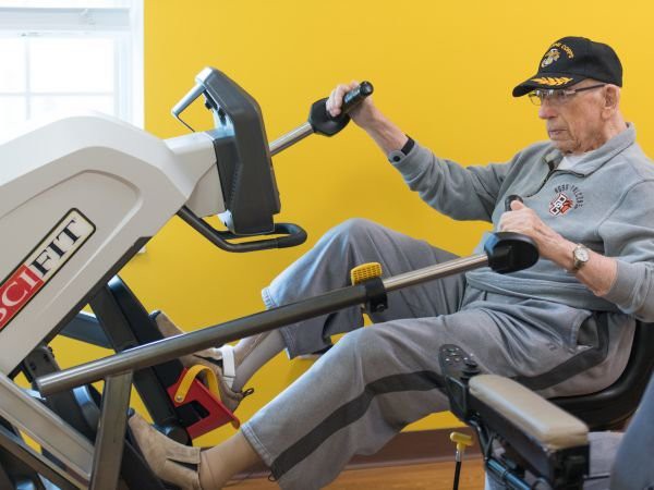 A senior individual using exercise equipment indoors.