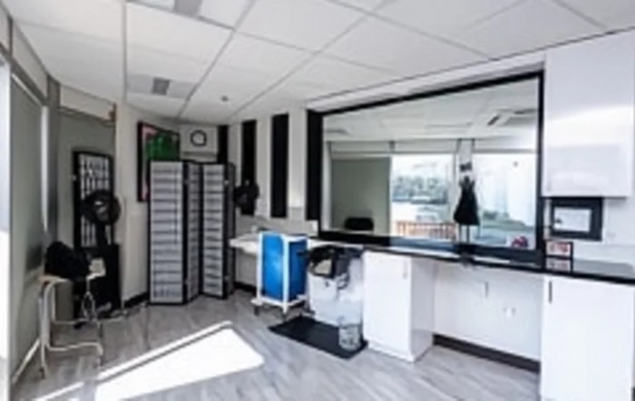A modern office workspace featuring a desk and large mirror.