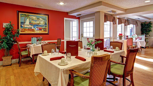 A cozy dining room with elegantly set tables and comfortable chairs.