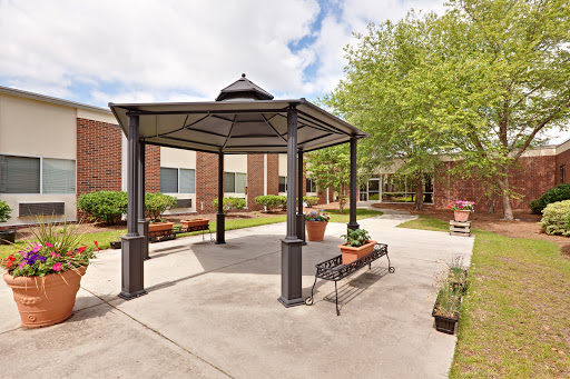 A serene outdoor gazebo surrounded by greenery in a courtyard setting.