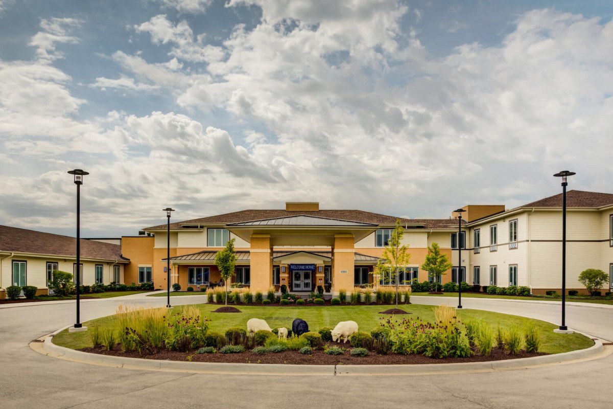 A modern building with landscaped surroundings under a cloudy sky.