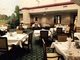 An outdoor restaurant seating area with tables and chairs arranged for dining.