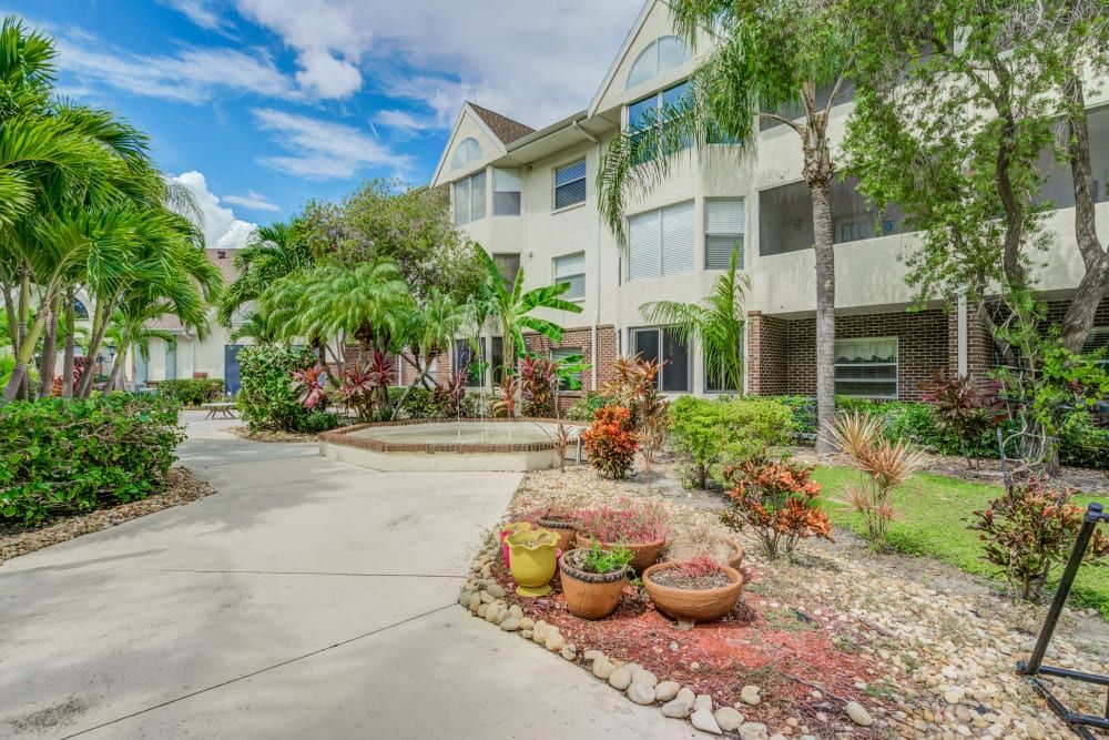 A well-landscaped apartment building with vibrant plants under a clear blue sky.