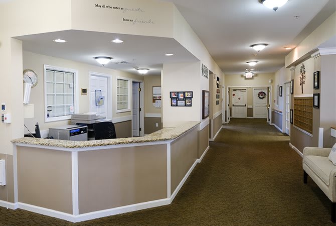 A spacious and well-lit office reception area with a corridor leading to multiple rooms.