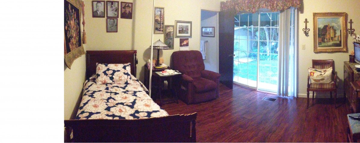 A cozy bedroom with a bed, recliner, and various wall decorations.
