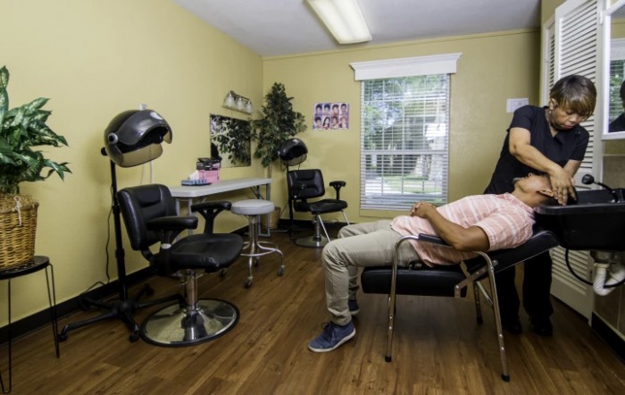A person relaxing on a chair in a hair salon with yellow walls.