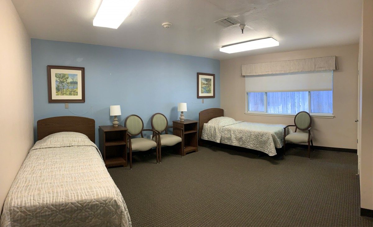 A neat and tidy bedroom with two single beds and simple furnishings.