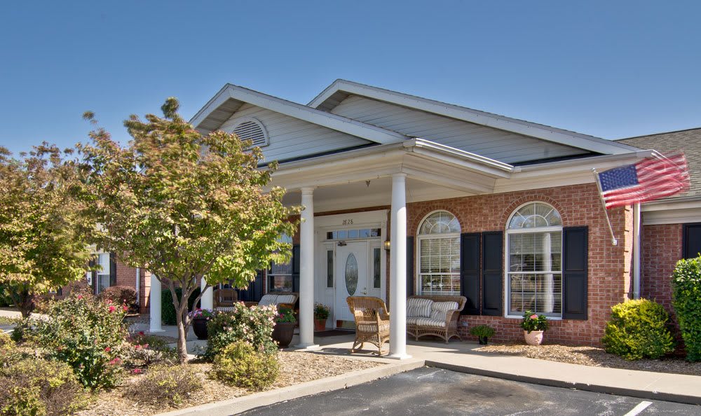 A suburban house with a porch and columns under a clear blue sky.