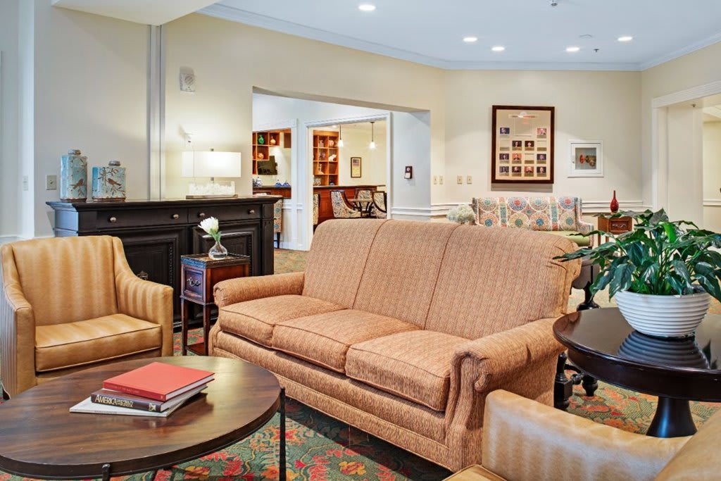 A cozy living room with a sofa, armchairs, and a fireplace.
