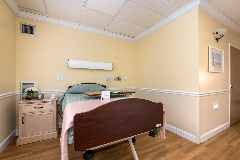 A clean and well-organized hospital room featuring a single bed.