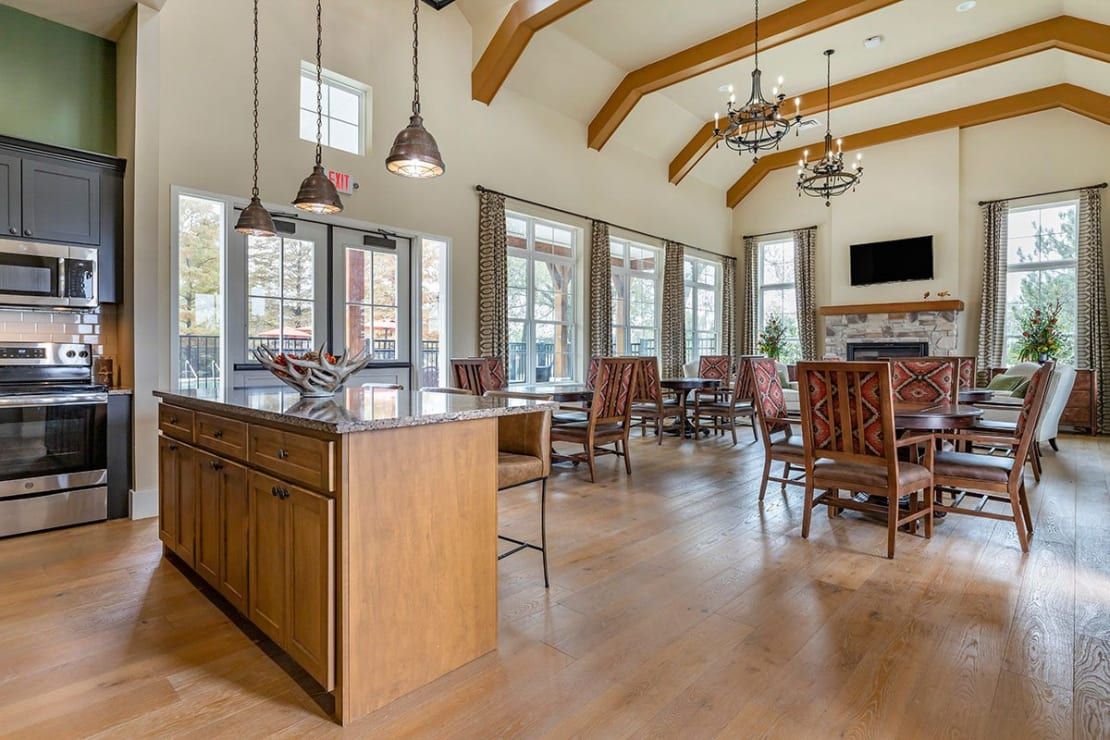 Spacious kitchen and dining area with high ceilings, ample natural light, and elegant chandeliers.