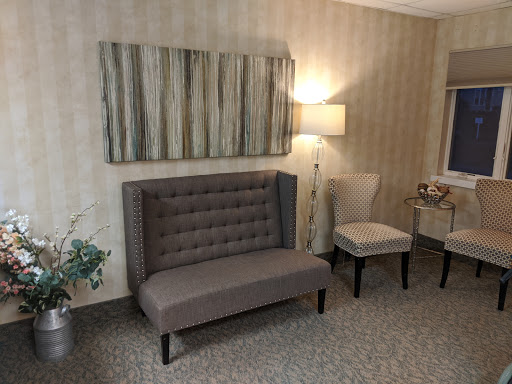A cozy living room setup featuring a stylish sofa, an elegant chair, and tasteful decor.
