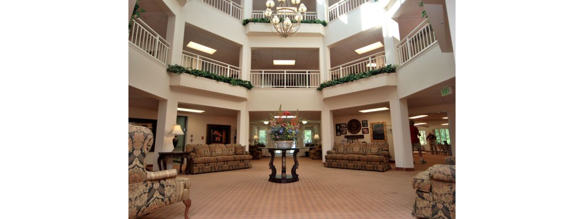 A spacious lobby with elegant decor, featuring a central chandelier and comfortable sitting areas.
