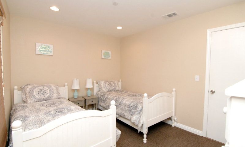 A cozy bedroom with twin beds and soft lighting.