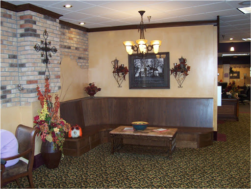 A cozy restaurant lobby featuring wooden furniture, decorative wall art, and warm lighting.