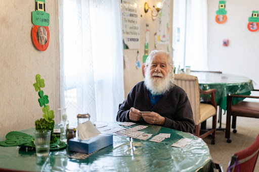 An elderly man enjoying a card game at a cozy table.
