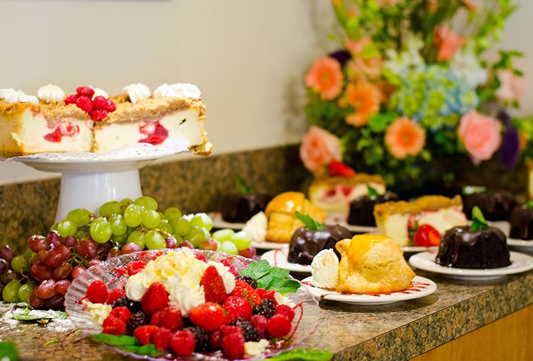 An assortment of delicious desserts and fruits displayed on a buffet table.