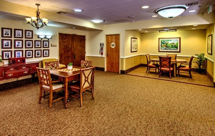 A cozy dining area with wooden tables and chairs, warm lighting, and tasteful decor.