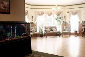 A cozy lobby with an aquarium and comfortable seating surrounded by plants.