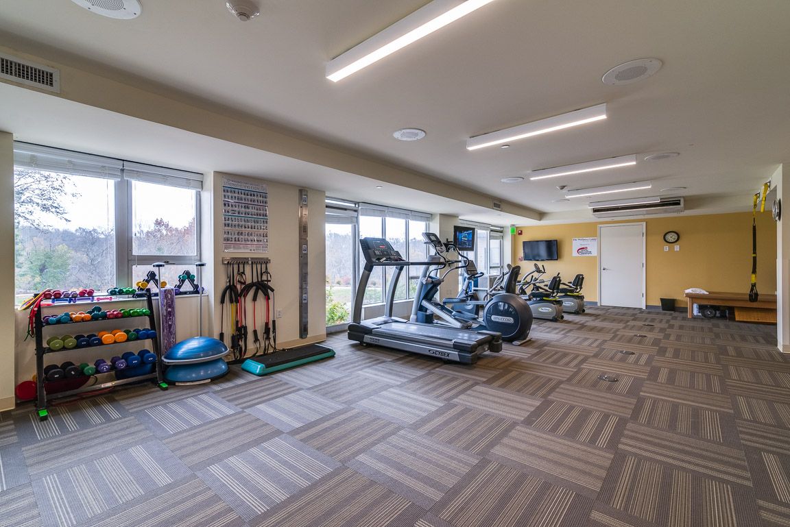A well-lit gym with treadmills and various fitness equipment.