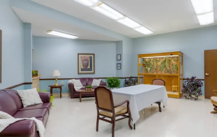 A cozy living room area with sofas, a table, and artwork on the walls.