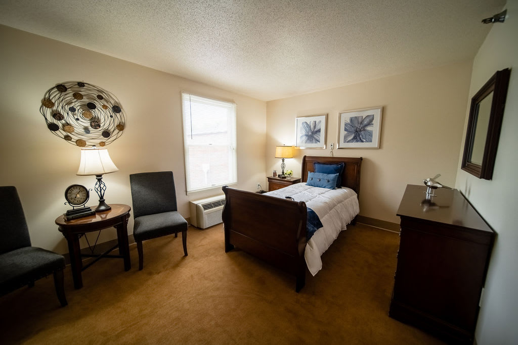 A cozy bedroom with a single bed, elegant decor, and warm lighting.