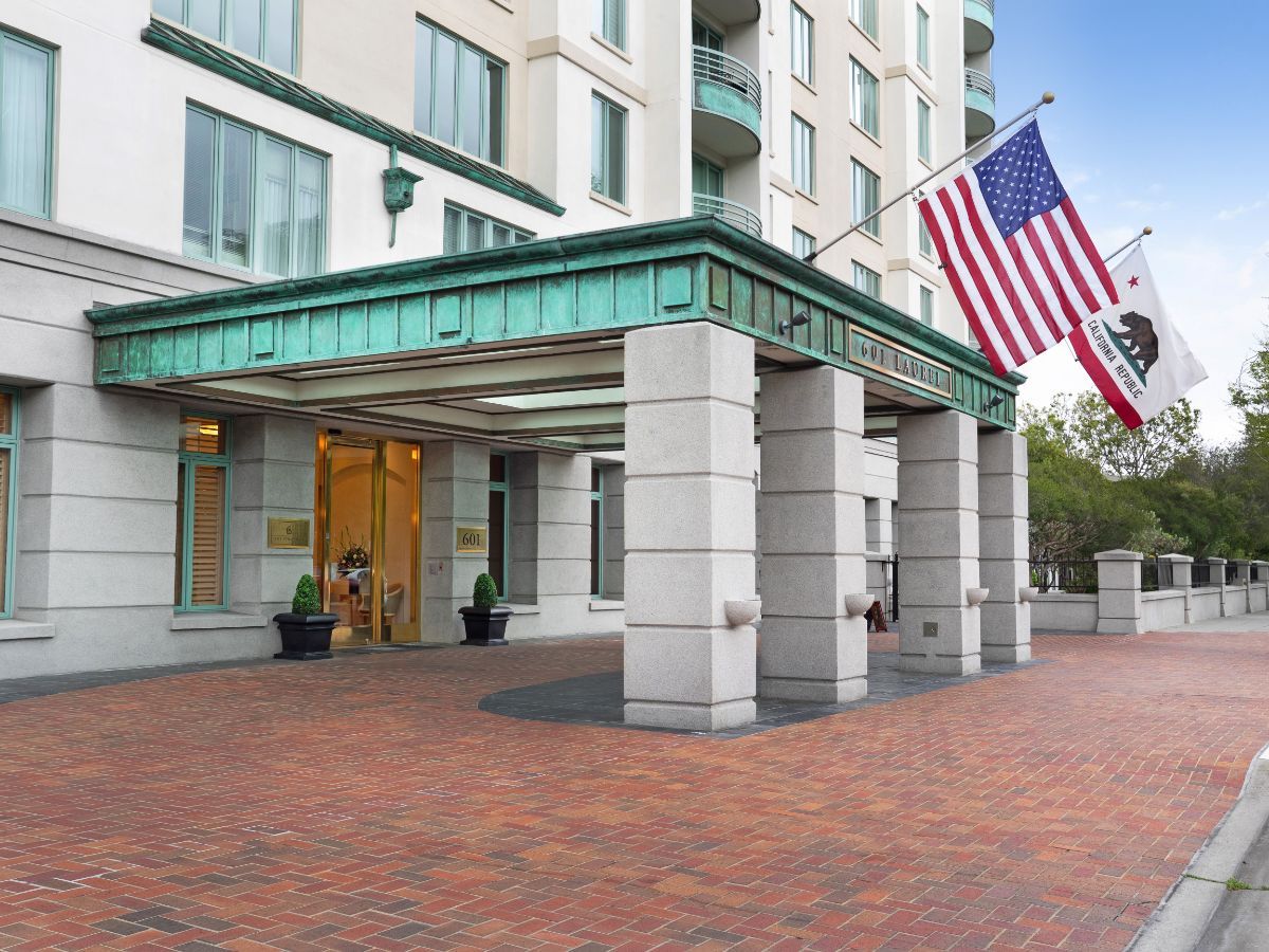 The entrance of a modern hotel with an American flag prominently displayed.