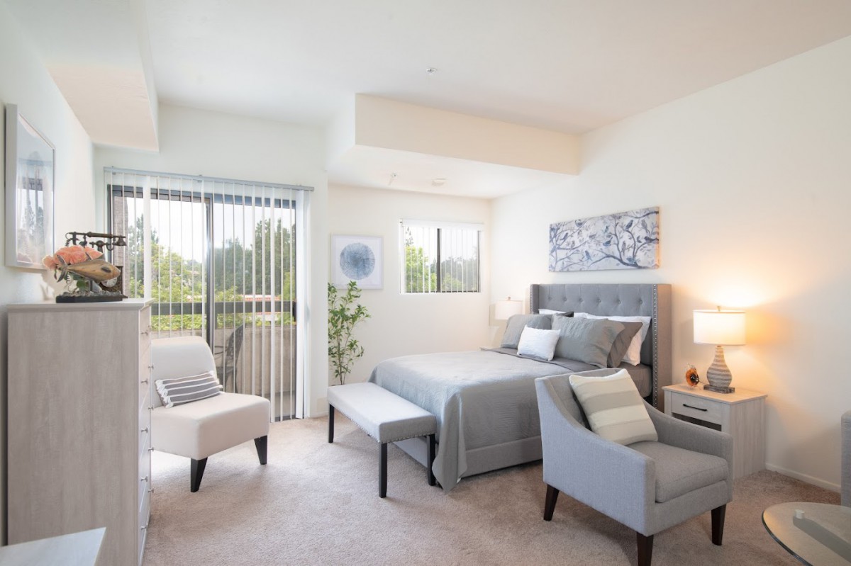 A modern and bright bedroom featuring elegant furniture and cozy decor.
