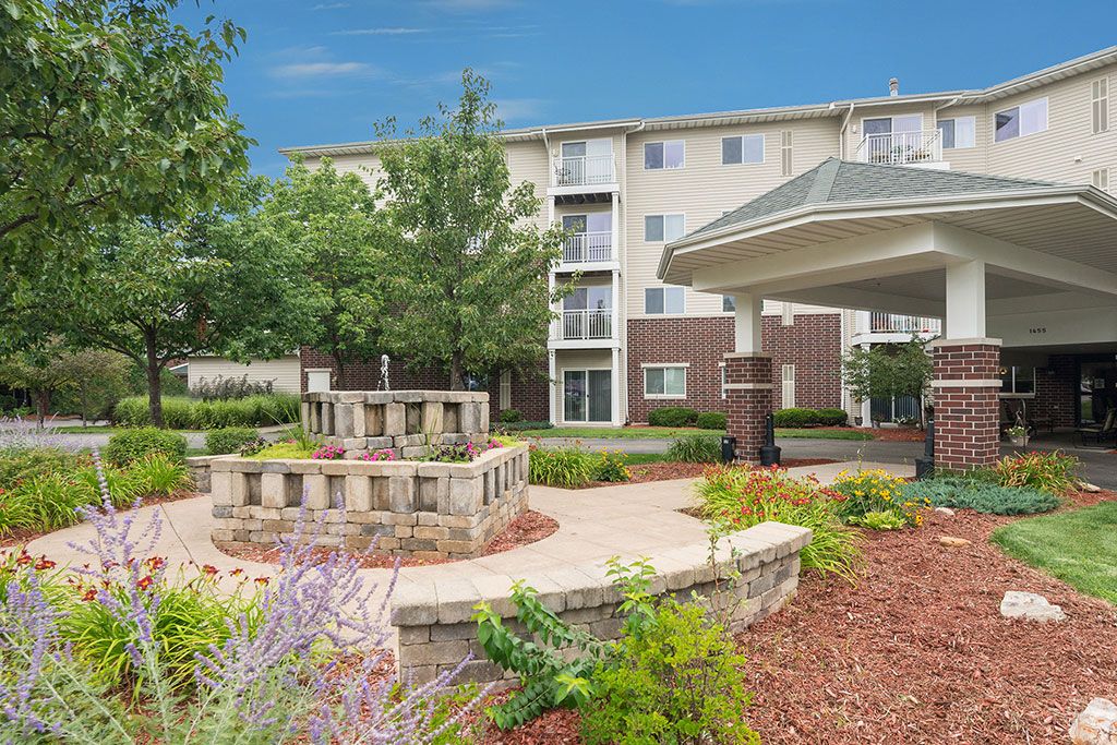 A well-landscaped outdoor area with a pathway leading to an apartment building.