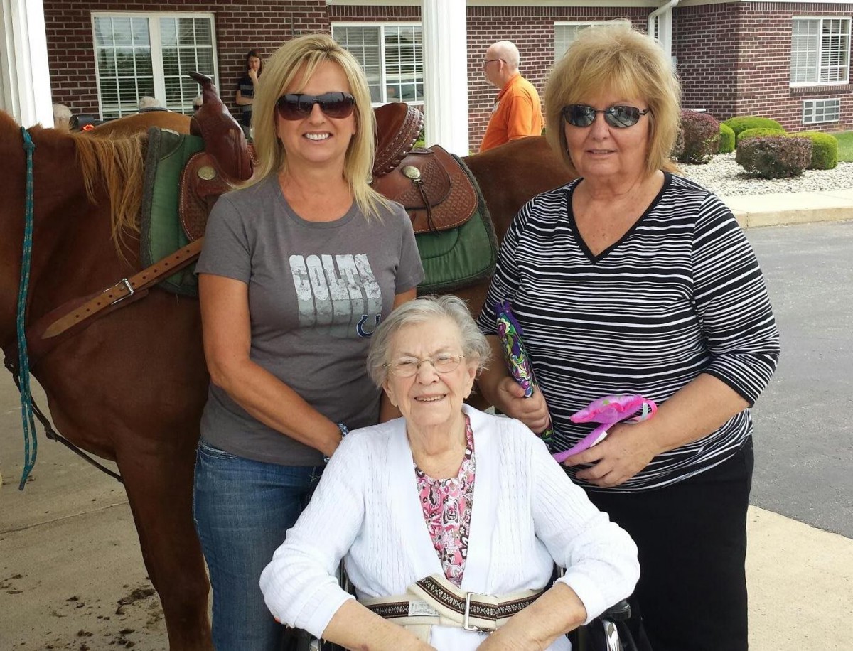 Three women enjoying a day outdoors, with one sitting in a wheelchair.