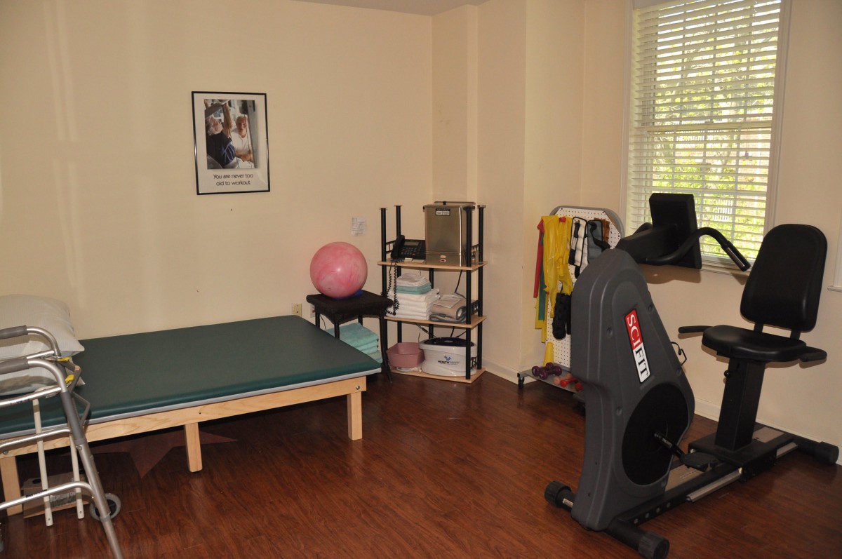 A small exercise room with fitness equipment including a stationary bike and an exercise ball.
