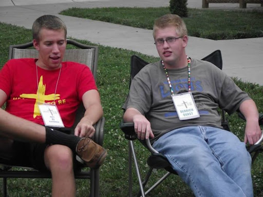 Two teenagers relaxing in chairs at an outdoor summer event.