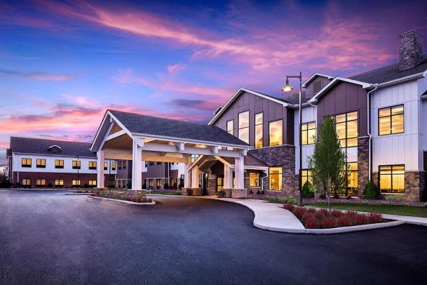 A modern residential building with a landscaped entrance at twilight.