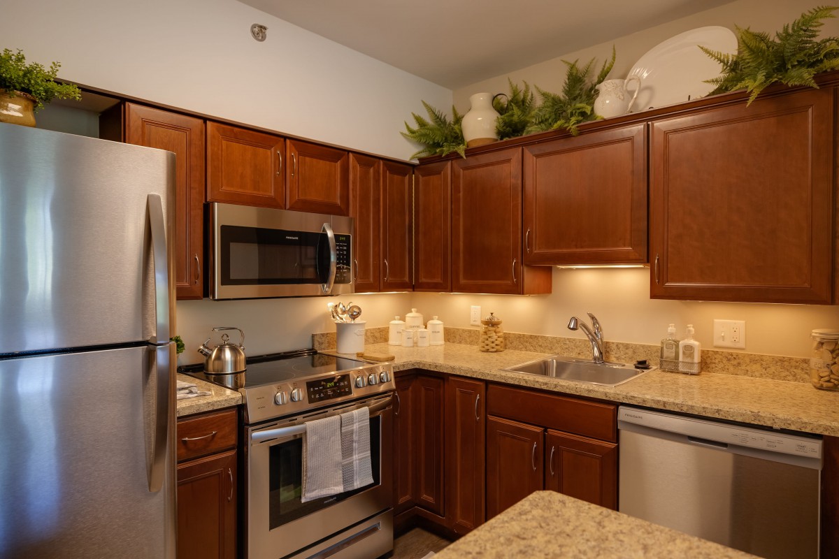 A modern kitchen with wood cabinets and stainless steel appliances.