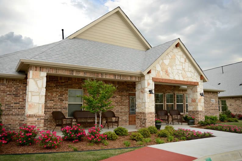 A cozy residential house with a brick exterior and a landscaped garden.